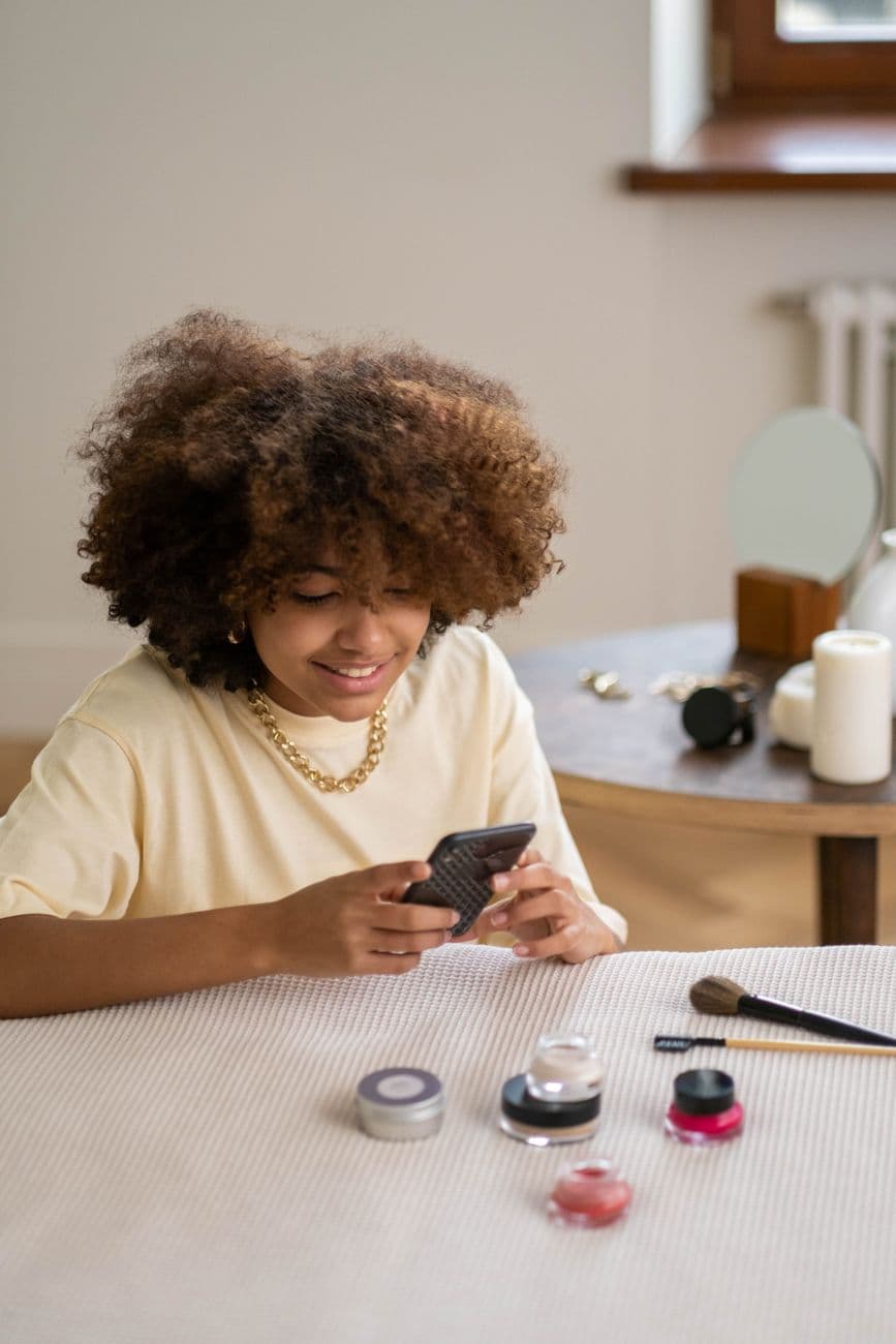 A woman with afro hair reviews beauty products in an indoor setting. · Ron Lach #8154656