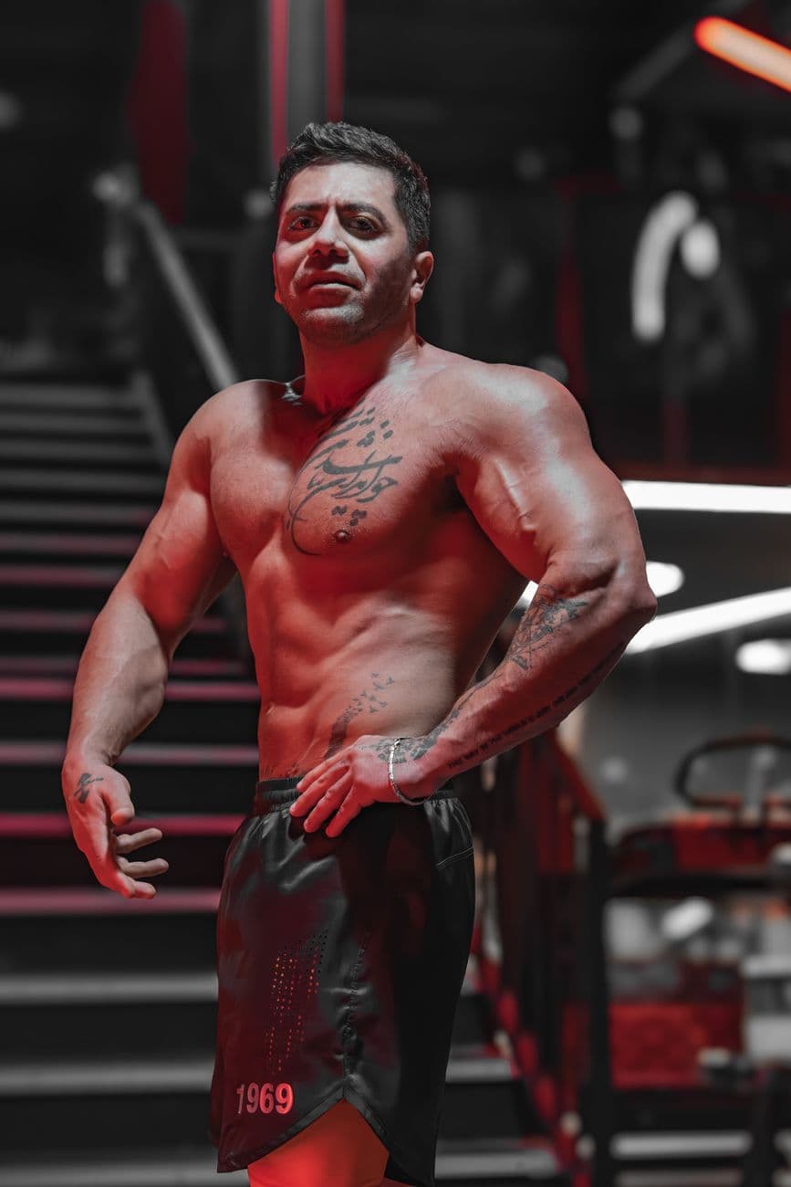 Tattooed bodybuilder posing confidently in a stylish gym environment. · foad shariyati #29526363